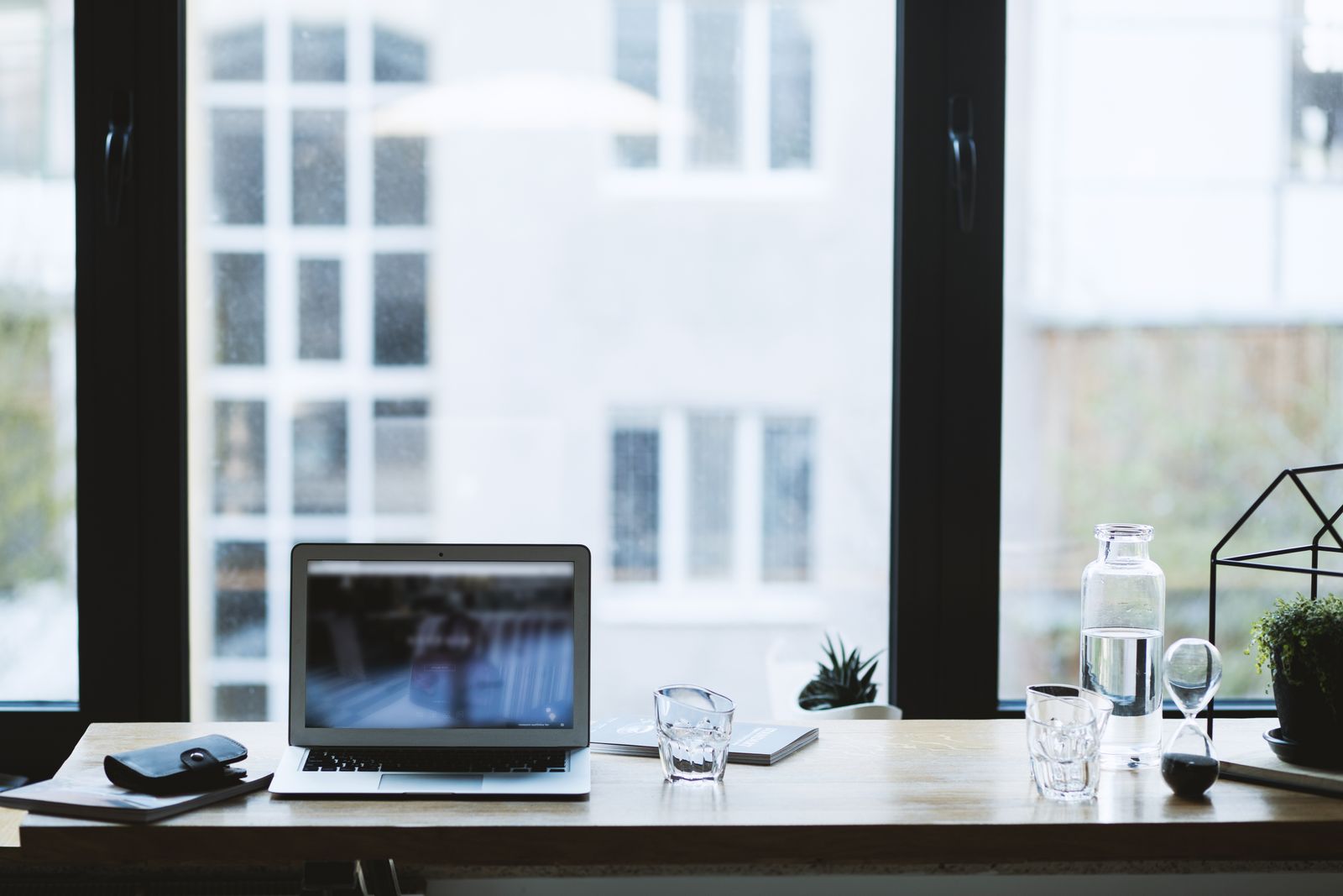 Ordinateur portable ouvert sur un bureau lumineux avec vue — choisir son IA pour l'immobilier