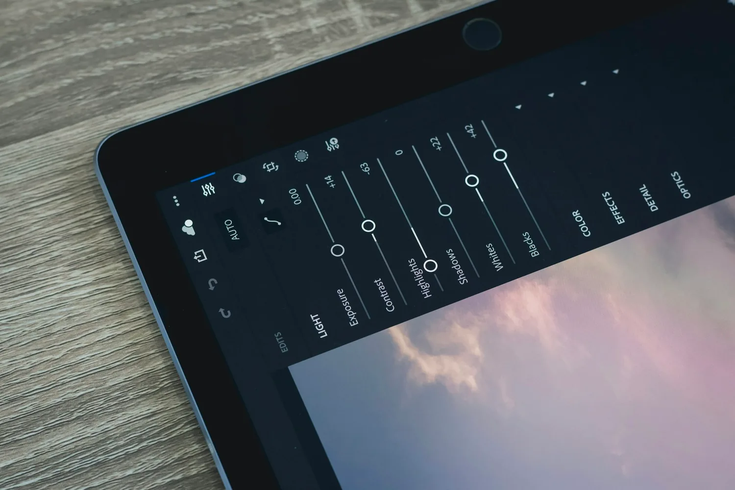 Tablette affichant un logiciel de retouche photo, curseurs d’exposition et de contraste ouverts
