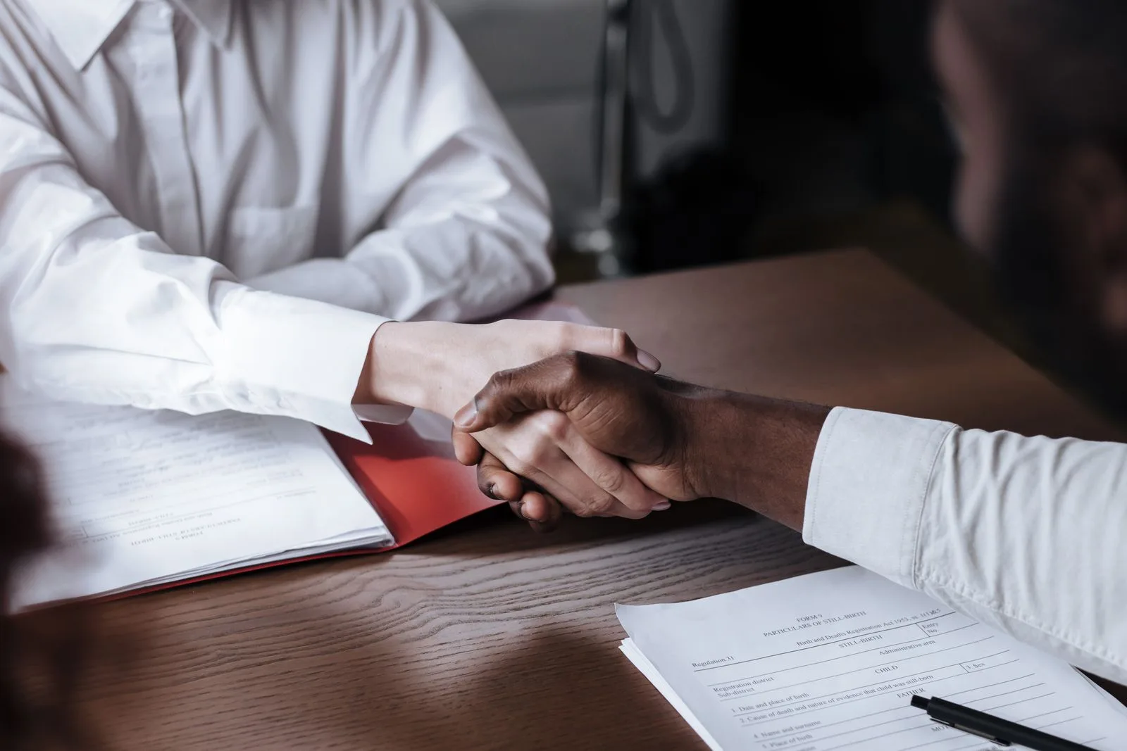 Poignée de main au-dessus d’un contrat immobilier