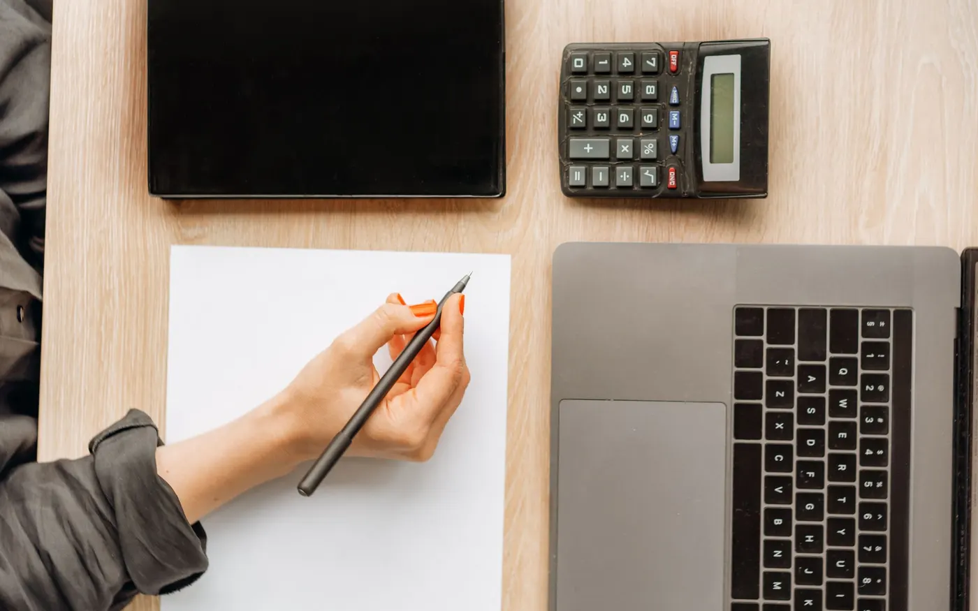 Une calculatrice, un portable et une feuille de notes sur un bureau