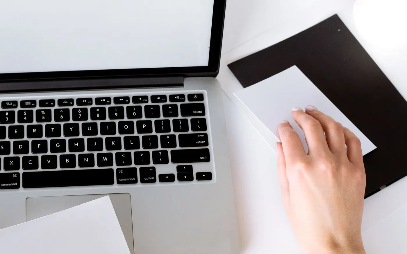 Un ordinateur portable et une tablette posés côte à côte sur un bureau blanc