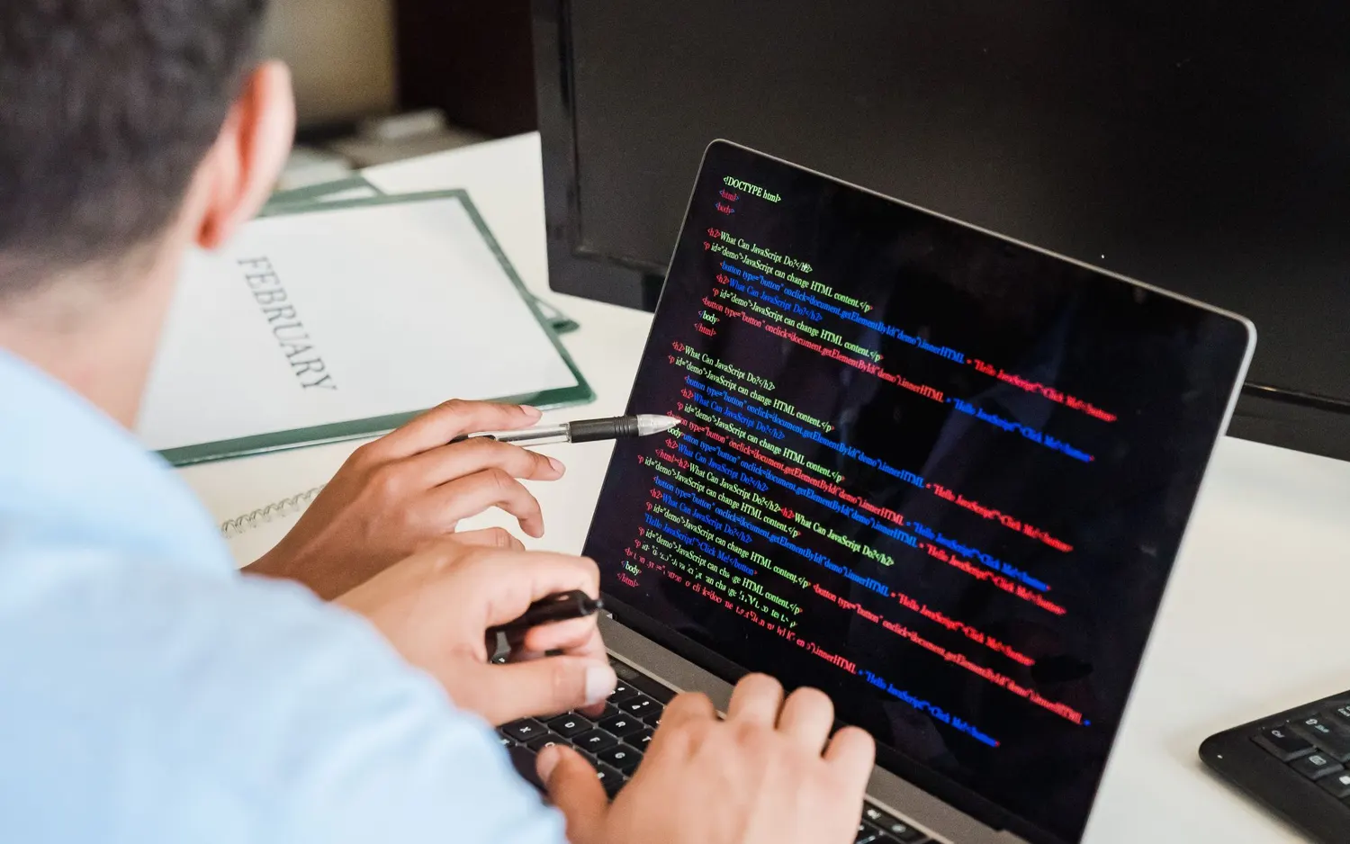 Une personne relit des lignes de code affichées sur son ordinateur portable
