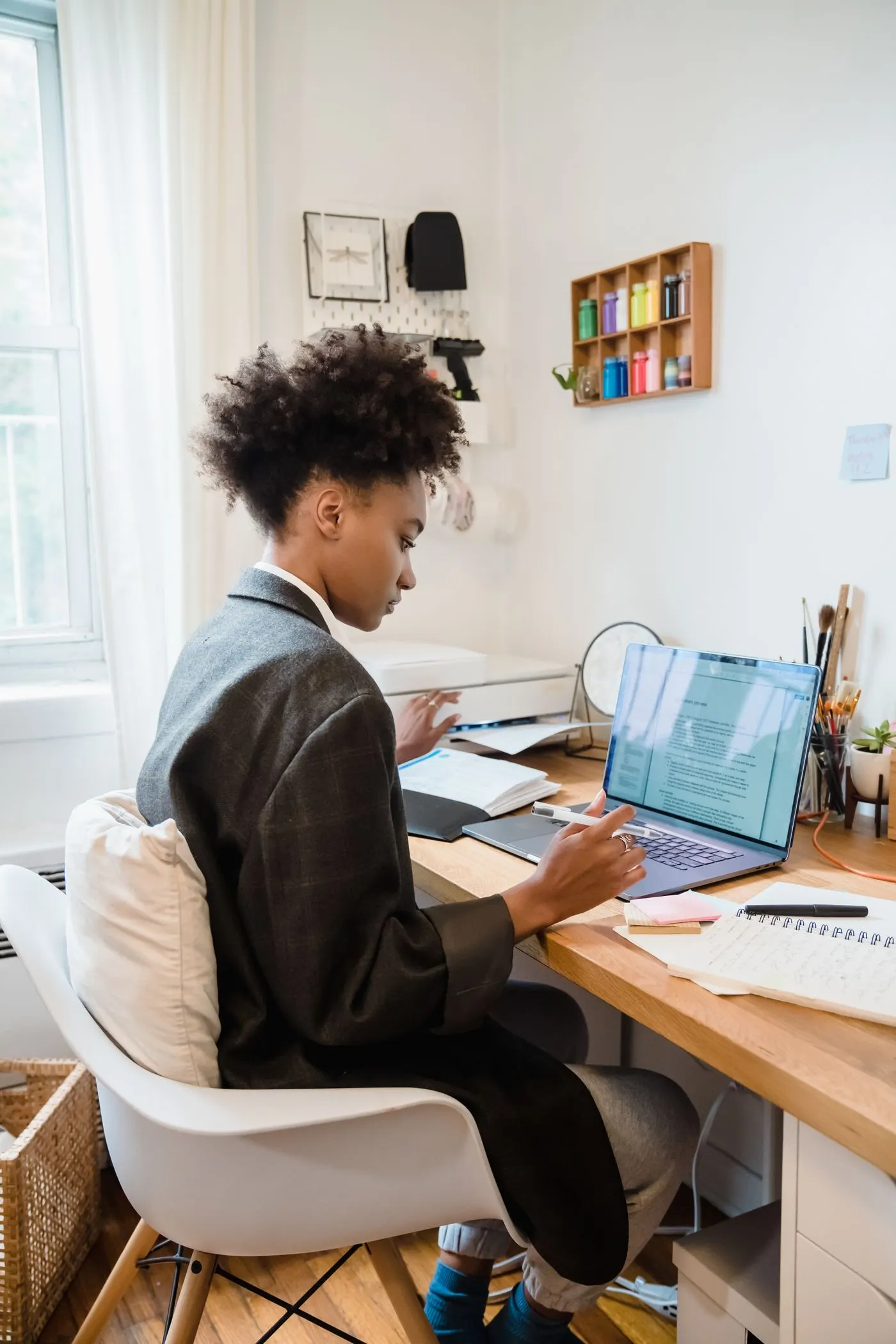 Une professionnelle travaille à son bureau, devant son ordinateur portable et ses notes