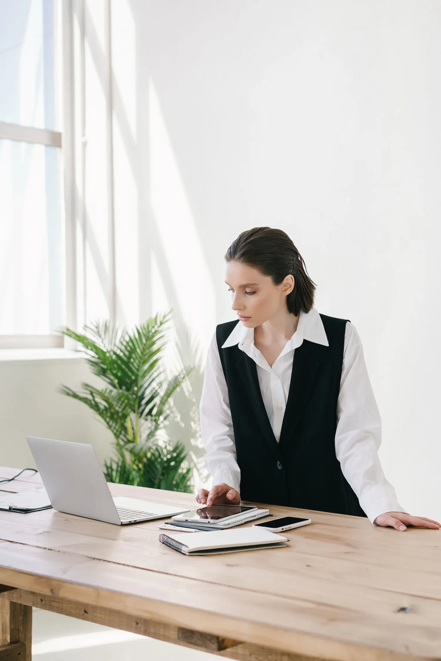 Une professionnelle travaille debout à son bureau, devant son ordinateur portable