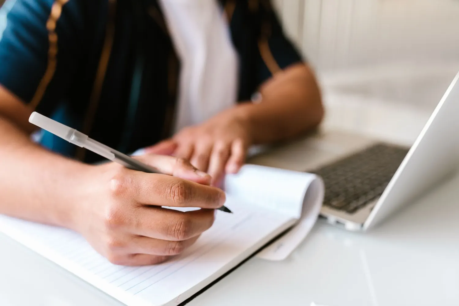Des notes prises à la main sur un carnet, posé sur une table de travail