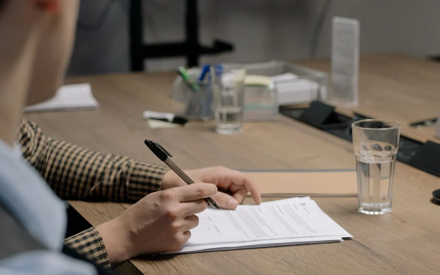 Une personne signe un document sur une table de réunion